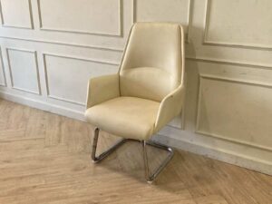 Office chair, leather upholstery, U-shaped steel legs, cream color.