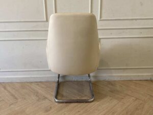 Office chair, leather upholstery, U-shaped steel legs, cream color.