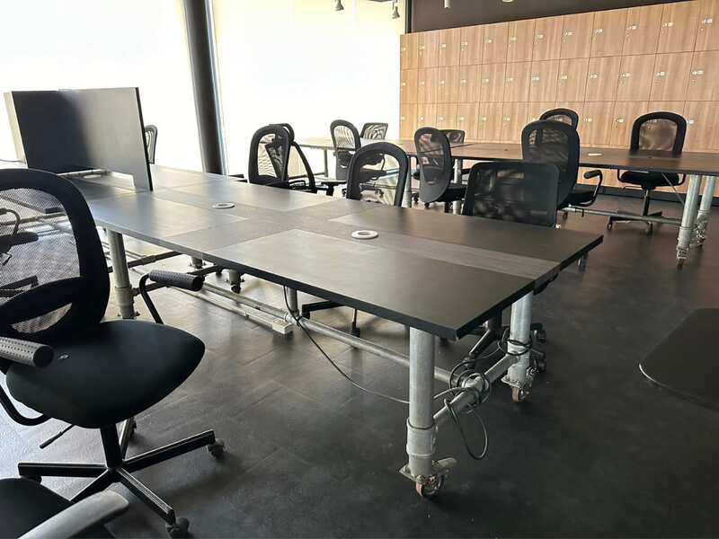 Work desk, 4 seats, steel frame, wooden top, black, with wheels.