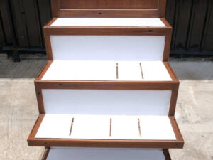 4 wooden product shelves (brown-white) with storage cabinets at the back.