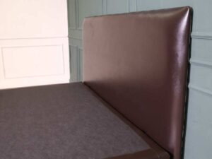6 foot bed, wooden frame, brown leather covering.