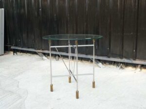 Round glass top table, cut glass, steel legs, hotel grade work.