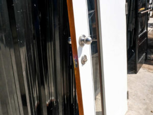 Wooden door with 2 different colored glass panels inside and outside, brown-white.