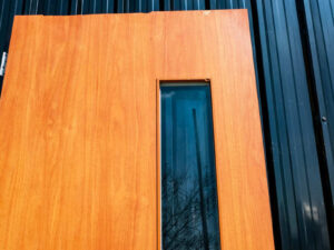 Wooden door with 2 different colored glass panels inside and outside, brown-white.
