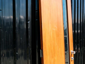 Wooden door with 2 different colored glass panels inside and outside, brown-white.