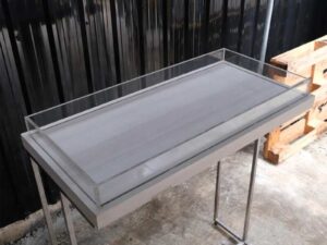 Tall wooden product display tray, attached to a clear acrylic frame. Product shelves, steel leg frame