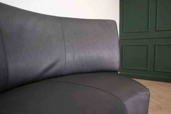 Curved leather sofa, beautiful shadow, wooden frame, black color.