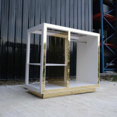 1 product shelf, 2 hanging rails, glass top, white wooden frame with shiny gold trim.
