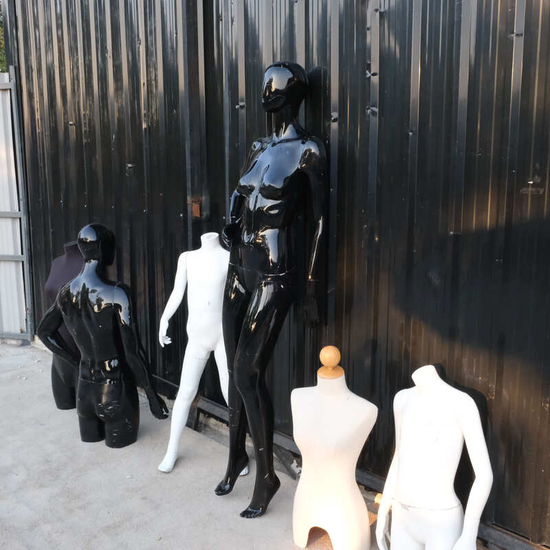 The mannequin showcases a full-body black women's shirt