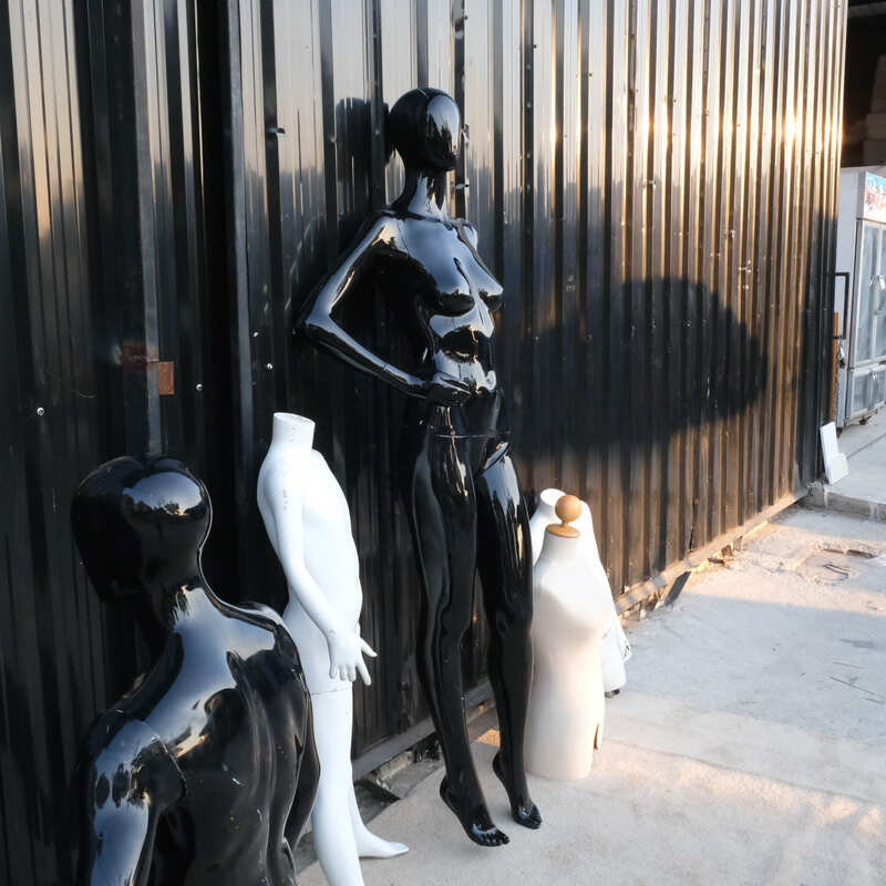 The mannequin showcases a full-body black women's shirt