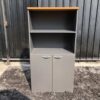 Tall file cabinet, 2 doors, gray color, wooden top.