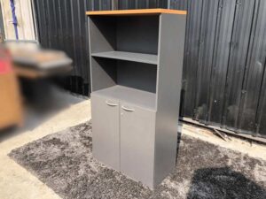 Tall file cabinet, 2 doors, gray color, wooden top.