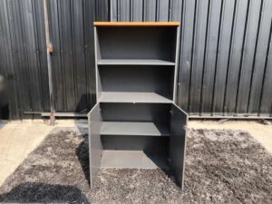 Tall file cabinet, 2 doors, gray color, wooden top.