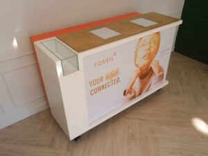 Orange and white counter with 3 storage doors at the back.