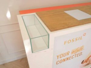 Orange and white counter with 3 storage doors at the back.