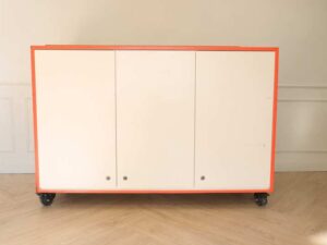 Orange and white counter with 3 storage doors at the back.