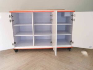 Orange and white counter with 3 storage doors at the back.