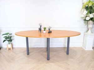 Conference table, steel legs, wooden top, oval shape.