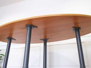 Conference table, steel legs, wooden top, oval shape.
