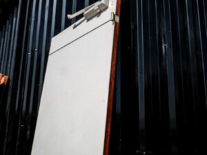 Wooden door, wood pattern outside, white inside, twist lock. There is a shock absorber to slow down opening and closing, Soft Close system.