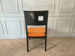 Wooden chair with orange fabric cushion, beautiful design with a hole in the backrest.