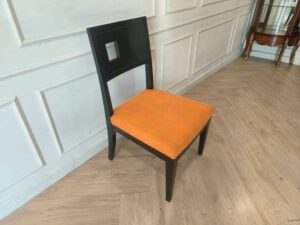 Wooden chair with orange fabric cushion, beautiful design with a hole in the backrest.