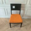 Wooden chair with orange fabric cushion, beautiful design with a hole in the backrest.
