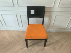 Wooden chair with orange fabric cushion, beautiful design with a hole in the backrest.