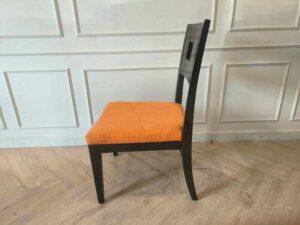Wooden chair with orange fabric cushion, beautiful design with a hole in the backrest.