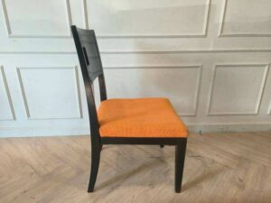 Wooden chair with orange fabric cushion, beautiful design with a hole in the backrest.