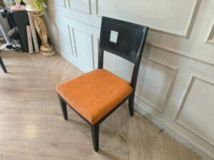Wooden chair with orange fabric cushion, beautiful design with a hole in the backrest.