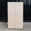 Wooden cabinet with 2 doors, cream color, wavy design.