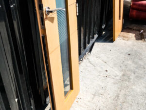 Tall, narrow wooden door with clear glass panels and lever-type knobs.