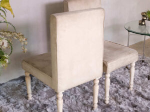 Wooden chair, beige fabric cushion, beautiful design on the legs.