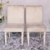 Wooden chair, beige fabric cushion, beautiful design on the legs.