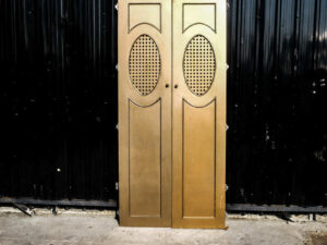 Double wooden doors, round mullions, twist latch, gold color.