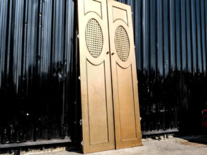 Double wooden doors, round mullions, twist latch, gold color.