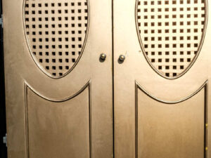 Double wooden doors, round mullions, twist latch, gold color.