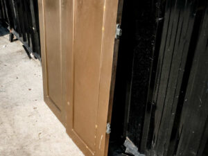 Double wooden doors, round mullions, twist latch, gold color.