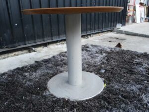 Round table, white steel legs, wooden top, light cream/beech wood color.