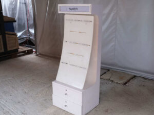 watch display shelf Hanging product display shelf, white wooden frame, with 2 storage drawers.