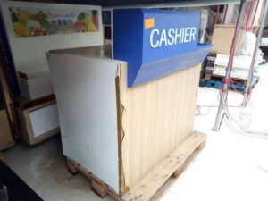 White cashier counter, blue CASHIER sign.