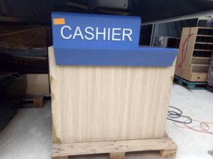 White cashier counter, blue CASHIER sign.