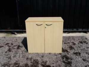 Document cabinet, 2 doors, open, wooden top, plain cream color.