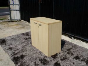 Document cabinet, 2 doors, open, wooden top, plain cream color.