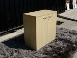 Document cabinet, 2 doors, open, wooden top, plain cream color.