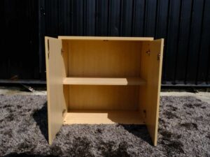 Document cabinet, 2 doors, open, wooden top, plain cream color.