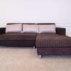 L sofa with pillows, fabric cushions, wooden frame, steel legs, brown.