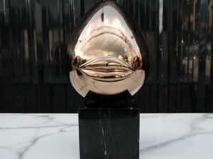Water decoration, golden shape, black marble base.