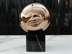 Water decoration, golden shape, black marble base.